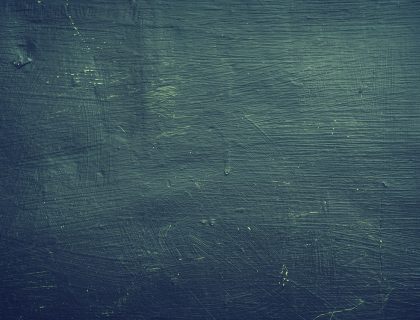 演员丙站在走廊尽头逆光处回头的身影，墙面斑驳，光线偏冷